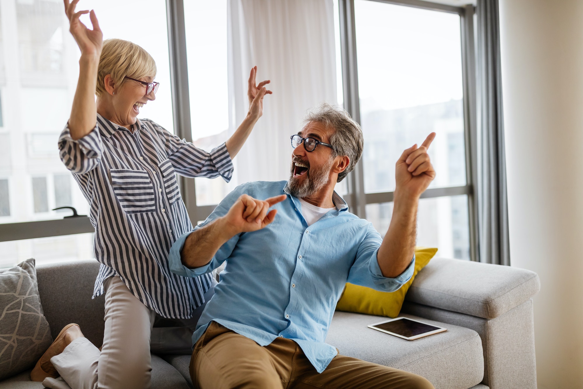 Cheerful senior couple enjoying life together, having fun at home